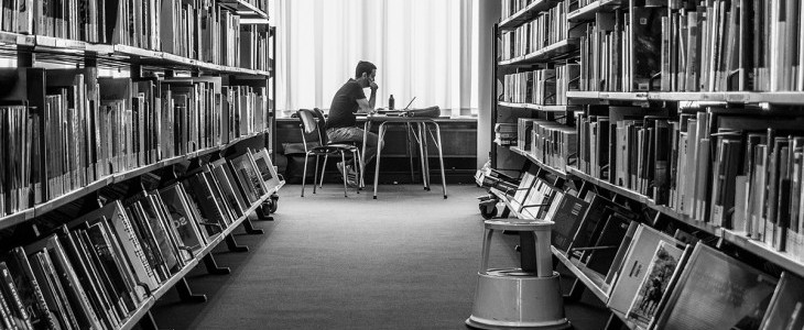 Person inside library black and white photo